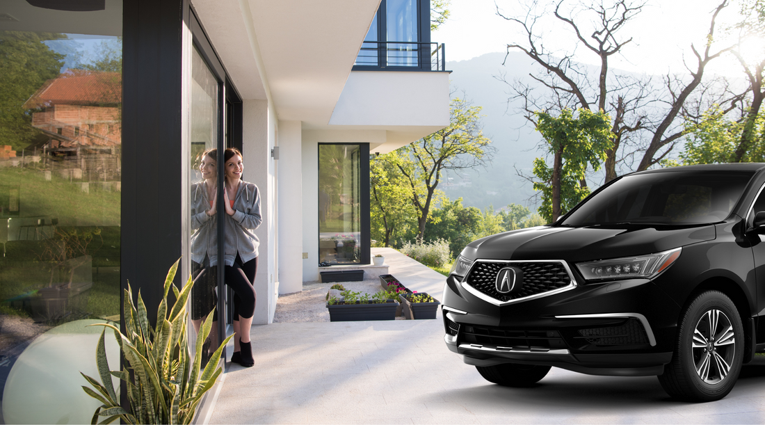 woman in doorway of home next to a black acura