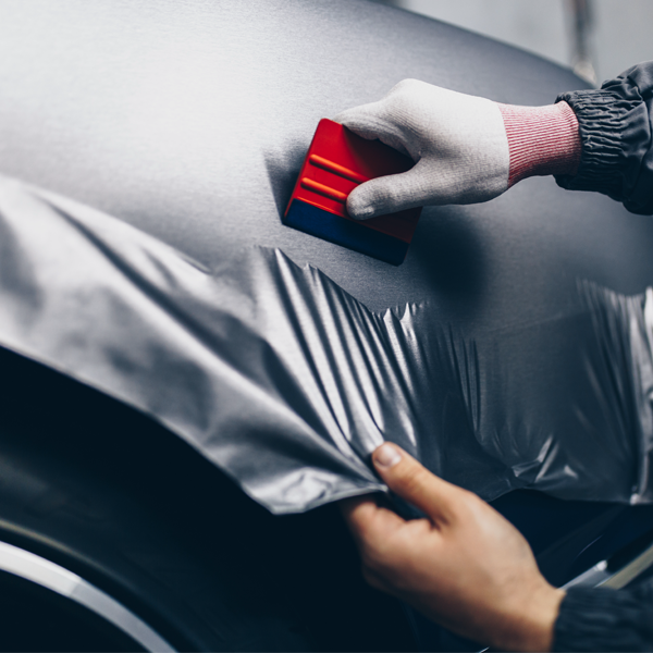 an installer applying wrap film on car