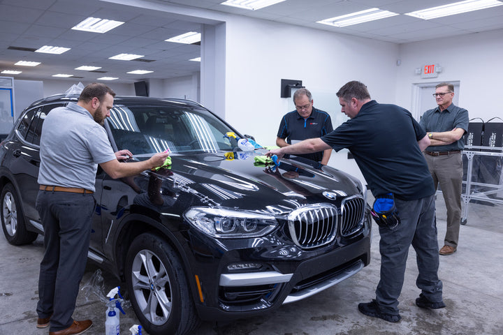Installation training, four men working on a car