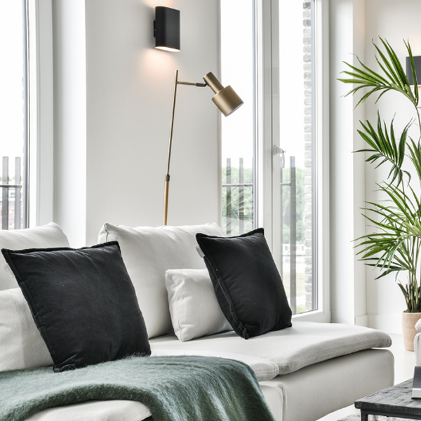 Residential living rom, white couch with black pillows near windows